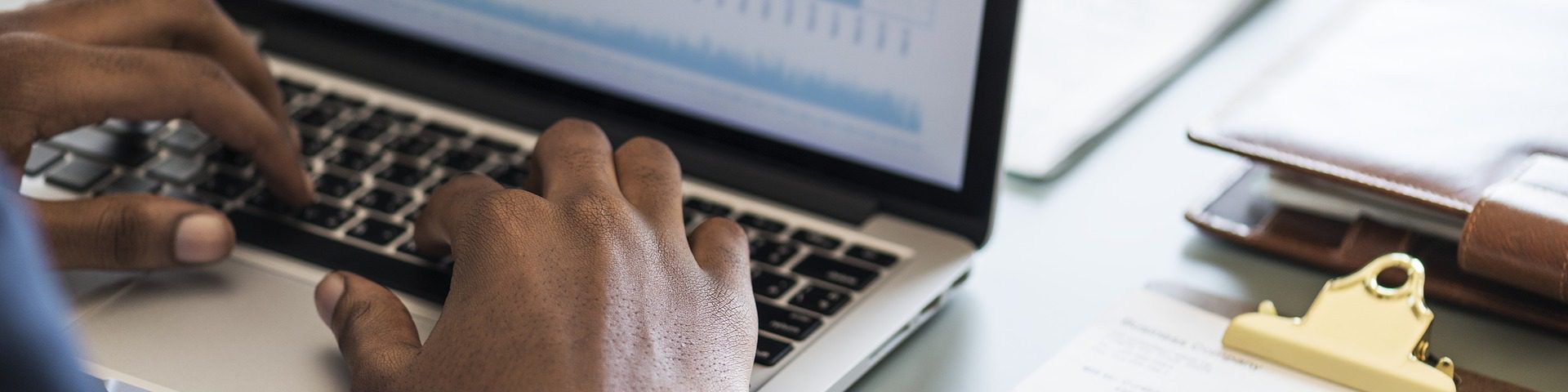 Manos sobre teclado de laptop